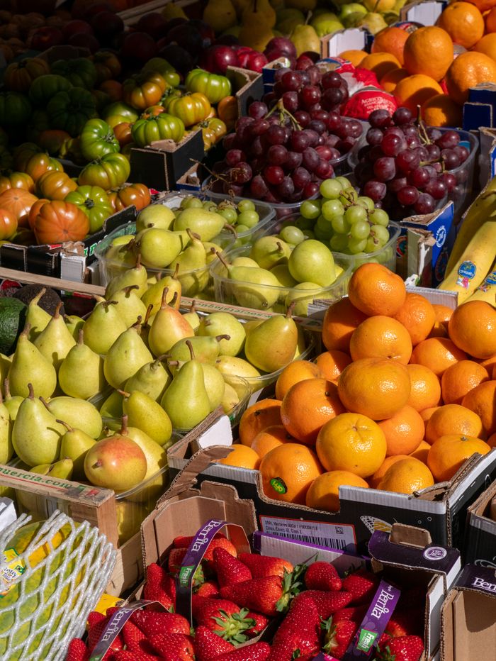 Bright and colorful assortment of fresh fruits at an outdoor market stall.